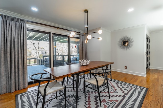 dining room with recessed lighting, crown molding, baseboards, and light wood-type flooring