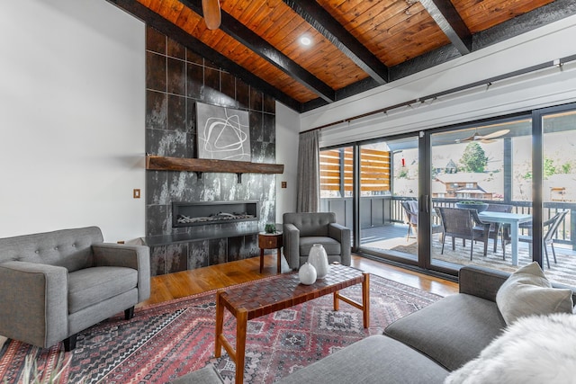 living room featuring wooden ceiling, high vaulted ceiling, beam ceiling, a fireplace, and wood finished floors