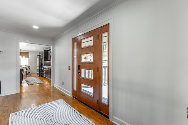 foyer featuring ornamental molding, baseboards, and wood finished floors