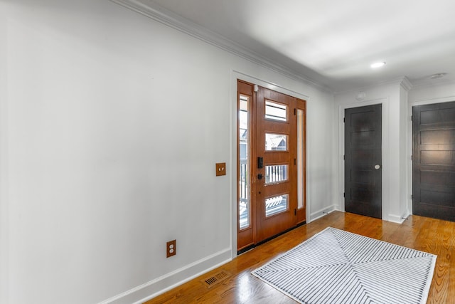 foyer featuring a wealth of natural light, baseboards, visible vents, and wood finished floors