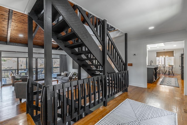 staircase with wood-type flooring, baseboards, and recessed lighting