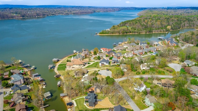 drone / aerial view featuring a water view, a forest view, and a residential view