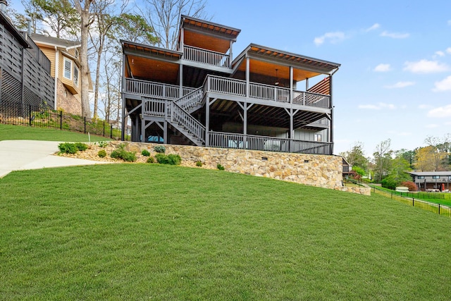 rear view of house featuring fence, stairway, and a yard