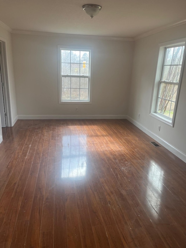 unfurnished room with ornamental molding, dark wood-type flooring, and baseboards