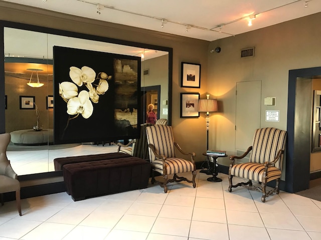 living area featuring track lighting, tile patterned floors, and visible vents