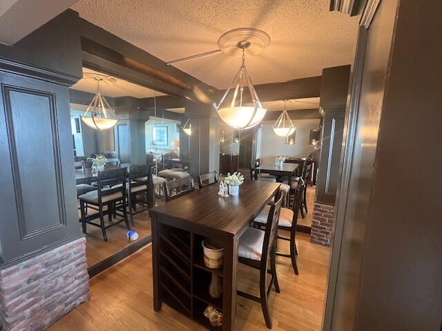 dining space with a textured ceiling and light wood-style floors