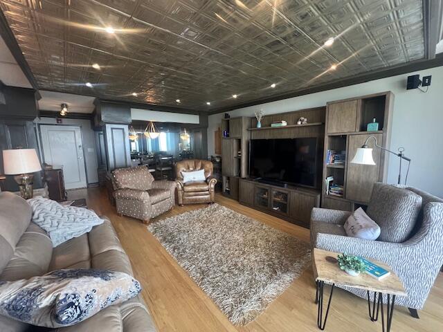living area with an ornate ceiling and wood finished floors