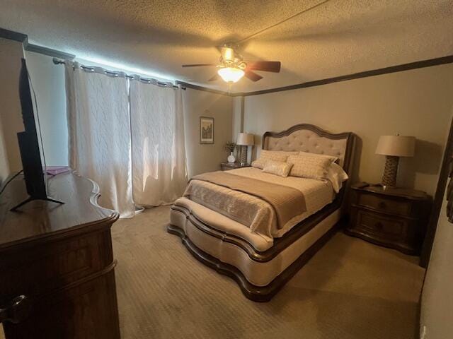 bedroom with a ceiling fan, a textured ceiling, light colored carpet, and ornamental molding