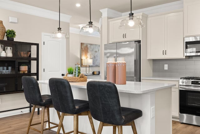 kitchen with decorative backsplash, light wood finished floors, ornamental molding, a kitchen bar, and stainless steel appliances