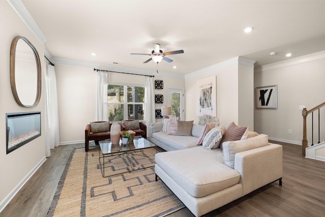 living room with crown molding, wood finished floors, baseboards, ceiling fan, and recessed lighting