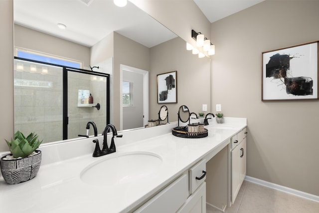 full bathroom with a stall shower, double vanity, baseboards, and a sink