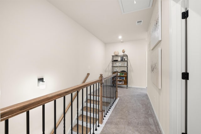 hall featuring baseboards, visible vents, an upstairs landing, and carpet floors