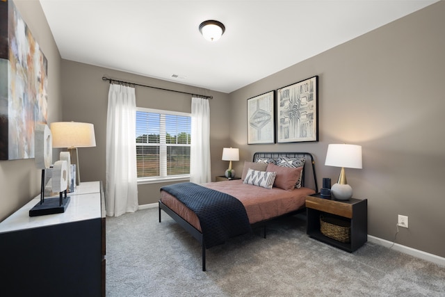 bedroom with baseboards, visible vents, and light carpet