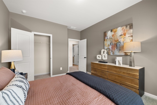 bedroom with baseboards, visible vents, a closet, and light carpet