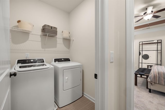 laundry area with washing machine and dryer, crown molding, light carpet, laundry area, and ceiling fan
