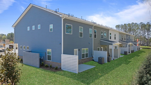 back of house featuring central AC and a yard