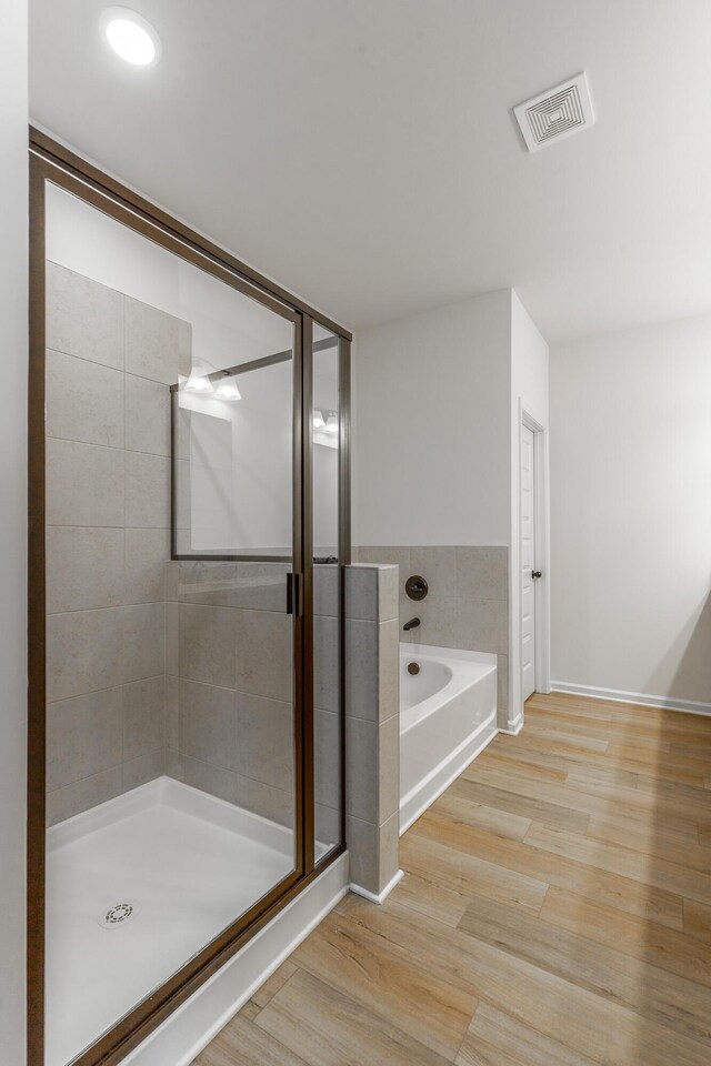 11304 Cape Vw, Soddy Daisy, TN 37379 - bathroom featuring a stall shower, a garden tub, wood finished floors, and baseboards