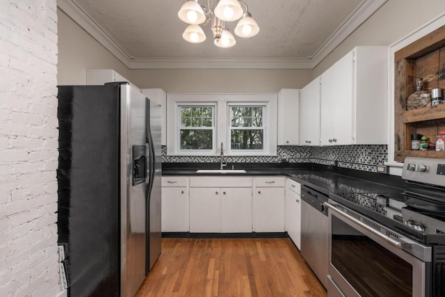 3308 Alta Vista Dr, Chattanooga, TN 37411 - kitchen featuring crown molding, stainless steel appliances, a chandelier, a sink, and dark countertops