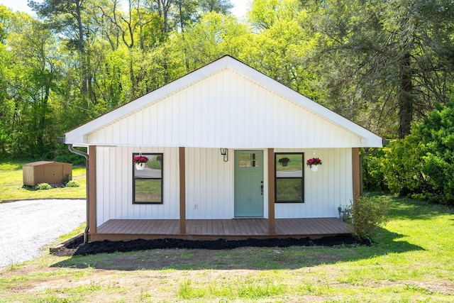 view of front of house featuring an outdoor structure and a front lawn