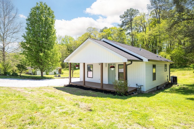 exterior space with a shingled roof, central AC, and a lawn