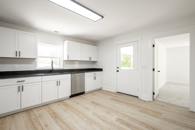 kitchen with stainless steel dishwasher, tasteful backsplash, visible vents, a sink, and light wood finished floors