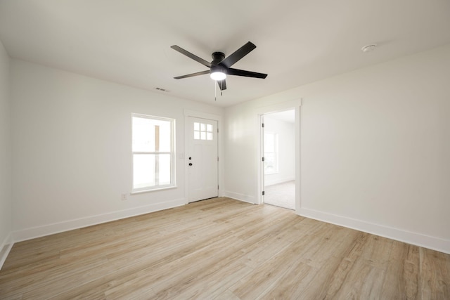 unfurnished room featuring light wood-type flooring, ceiling fan, baseboards, and visible vents