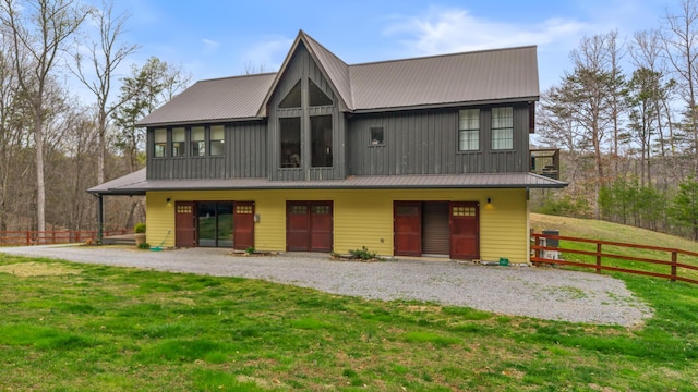 view of front of home with metal roof, a front yard, and fence