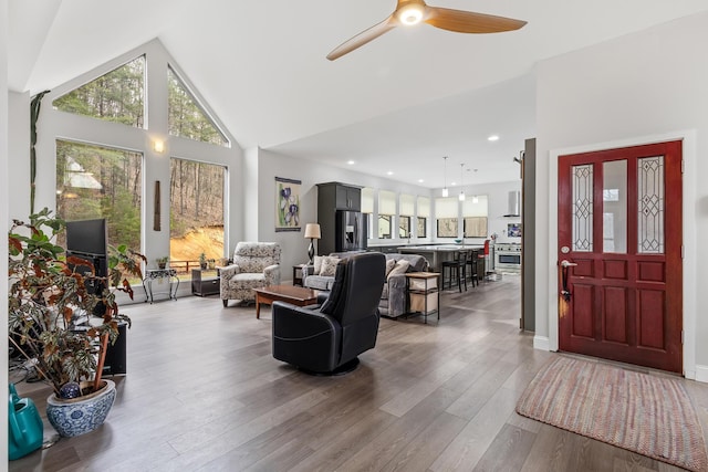 living room featuring a ceiling fan, recessed lighting, high vaulted ceiling, and wood finished floors