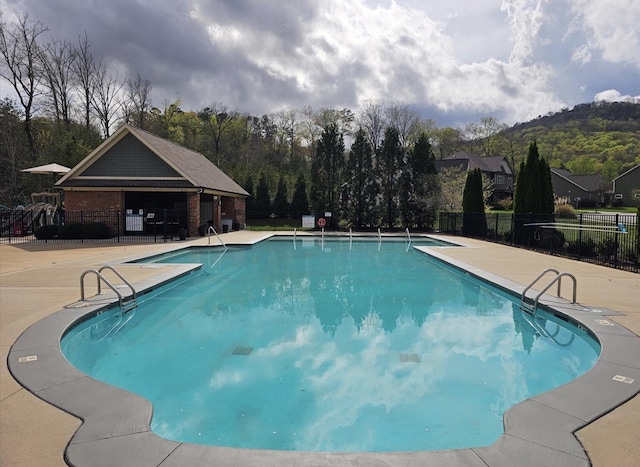 pool featuring fence and a patio area