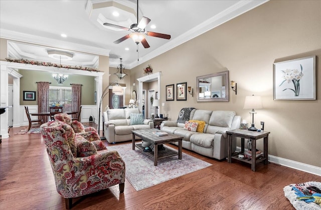 living area with crown molding, baseboards, wood finished floors, and a ceiling fan