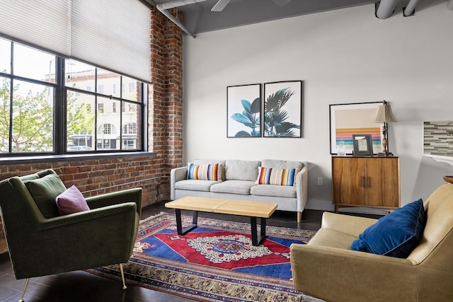 living area featuring brick wall and ceiling fan
