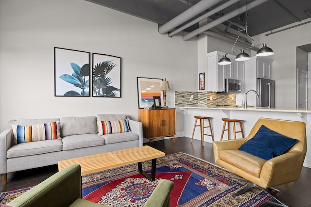 living room with a high ceiling and dark wood-type flooring