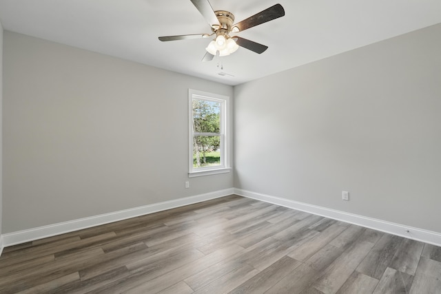 unfurnished room featuring a ceiling fan, baseboards, and wood finished floors
