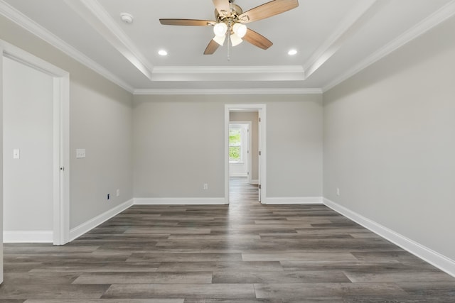 empty room with a tray ceiling, baseboards, ceiling fan, and dark wood-style floors