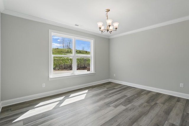 empty room with an inviting chandelier, crown molding, baseboards, and dark wood-type flooring