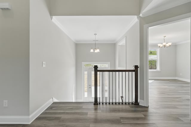 staircase with baseboards, wood finished floors, an inviting chandelier, and crown molding