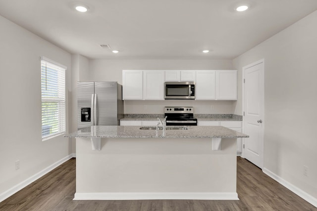 kitchen featuring white cabinetry, a sink, visible vents, a kitchen island with sink, and appliances with stainless steel finishes