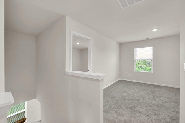 empty room featuring baseboards, visible vents, recessed lighting, and carpet