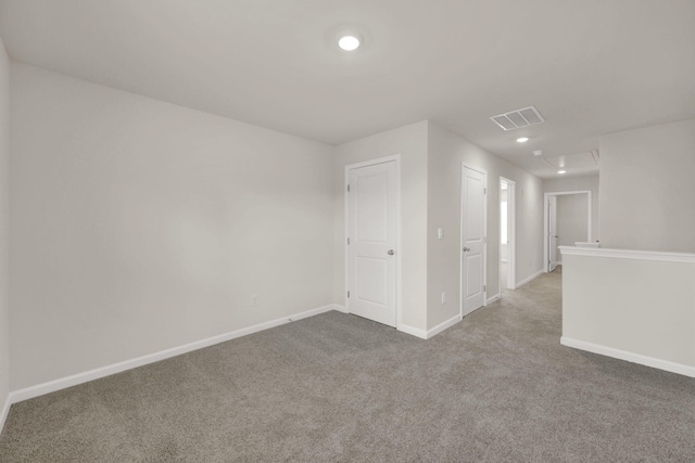 carpeted spare room with baseboards, visible vents, and recessed lighting