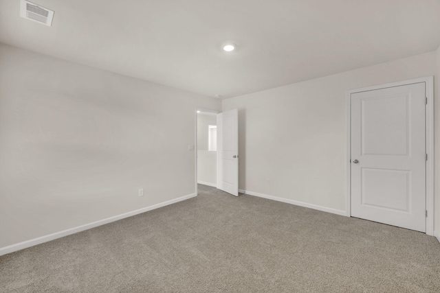 spare room featuring baseboards, carpet flooring, and visible vents
