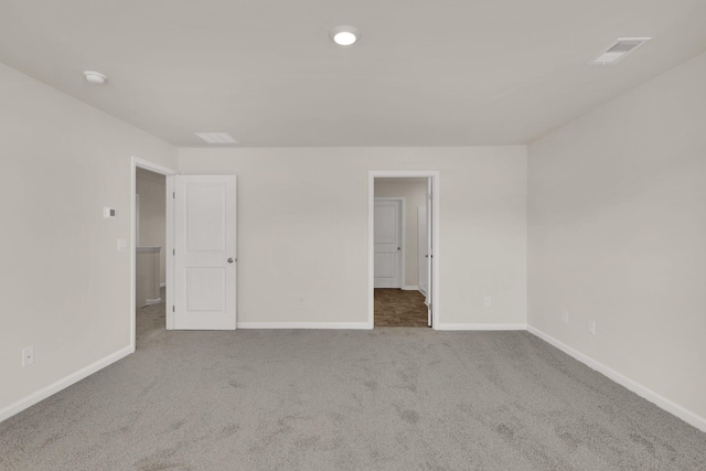 empty room with carpet flooring, baseboards, and visible vents