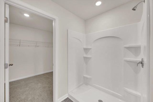 bathroom with a stall shower, baseboards, recessed lighting, and a walk in closet