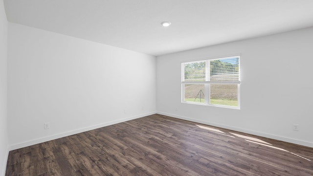 spare room with dark wood finished floors and baseboards