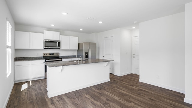 kitchen with white cabinetry, a sink, a kitchen island with sink, and appliances with stainless steel finishes