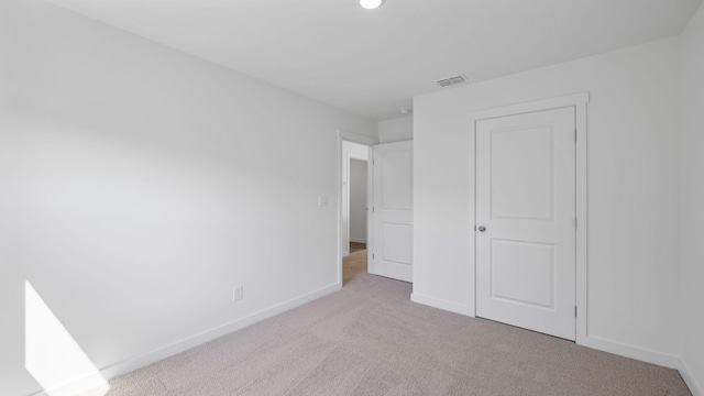 unfurnished bedroom featuring baseboards, visible vents, and carpet floors