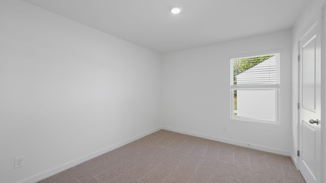 spare room with light colored carpet, recessed lighting, and baseboards
