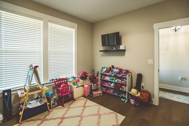 rec room with baseboards and wood finished floors