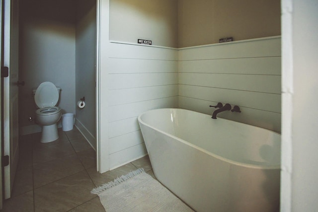 full bath featuring toilet, tile patterned floors, and a freestanding bath