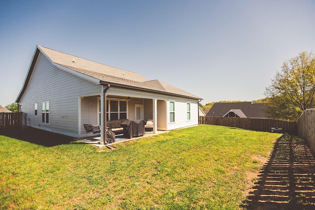 back of house featuring a shingled roof, a patio area, outdoor lounge area, a lawn, and a fenced backyard