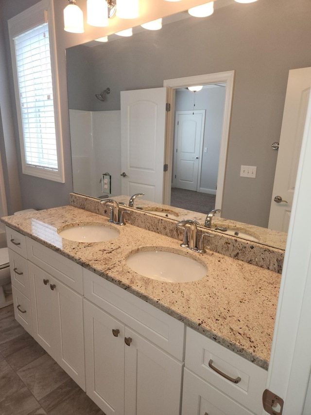 full bathroom with toilet, a sink, and walk in shower
